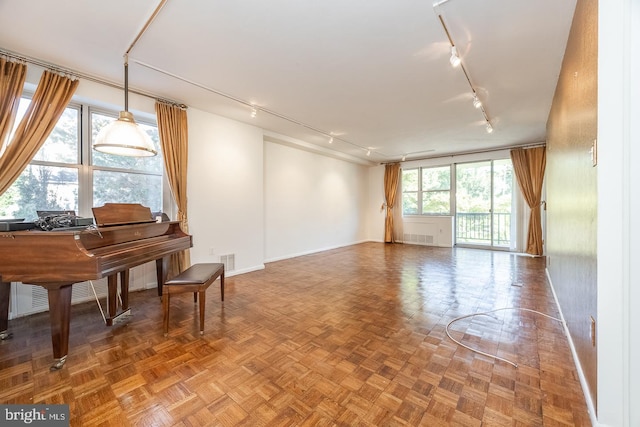 misc room featuring parquet flooring and rail lighting