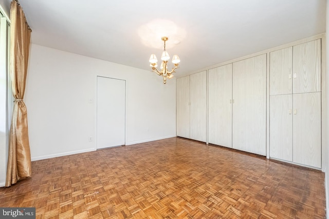 unfurnished bedroom featuring a notable chandelier and parquet floors