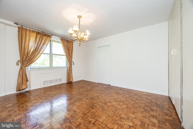 empty room with parquet flooring and a chandelier