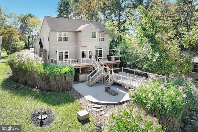 back of property featuring a deck, a yard, and a patio area