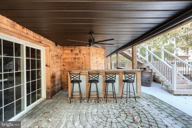 view of patio featuring ceiling fan and exterior bar