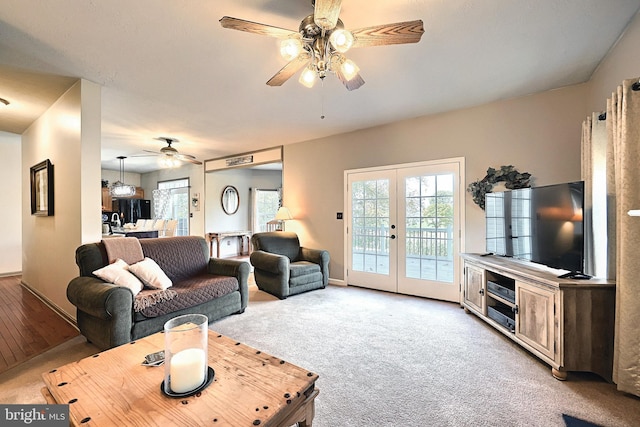 living room featuring french doors, light colored carpet, and ceiling fan