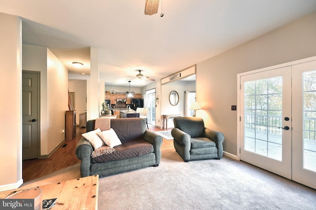 carpeted living room featuring ceiling fan and french doors