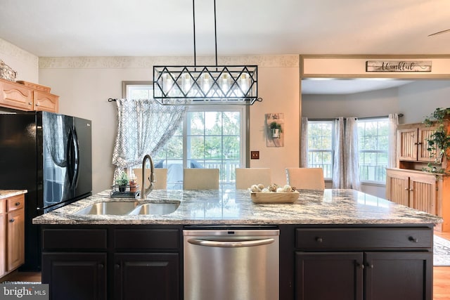 kitchen with light stone countertops, stainless steel dishwasher, sink, and light hardwood / wood-style floors