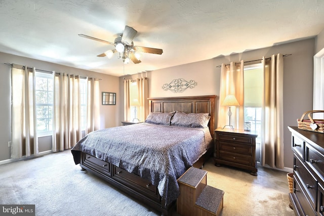 carpeted bedroom with a textured ceiling and ceiling fan