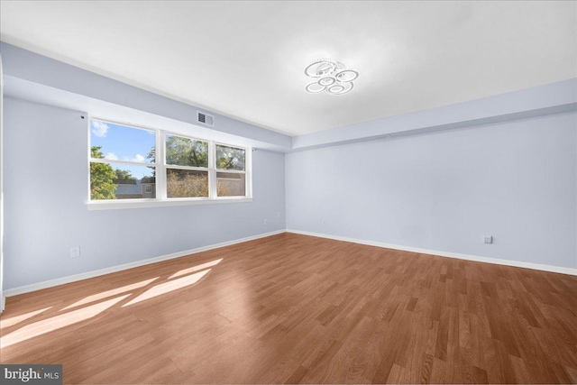 spare room with wood-type flooring