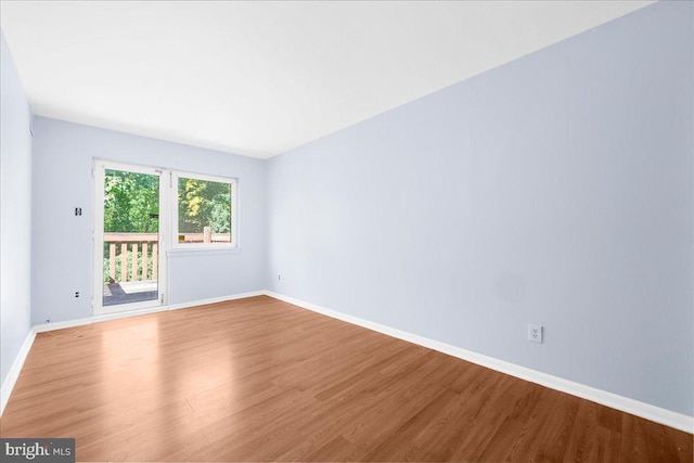 unfurnished room featuring baseboards and wood finished floors