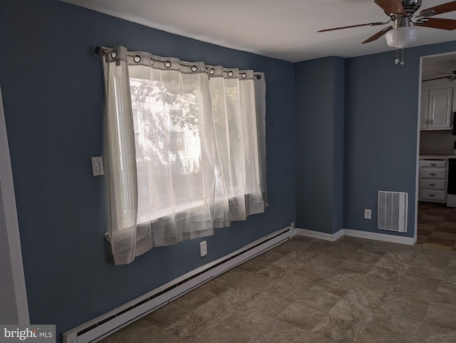 spare room with baseboards, a ceiling fan, visible vents, and a baseboard heating unit