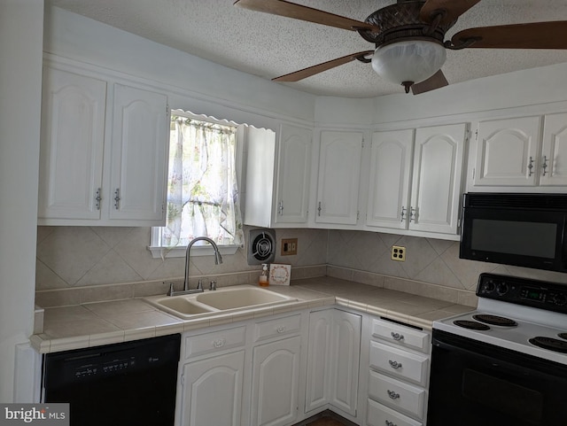 kitchen featuring white cabinets, tasteful backsplash, tile countertops, black appliances, and sink