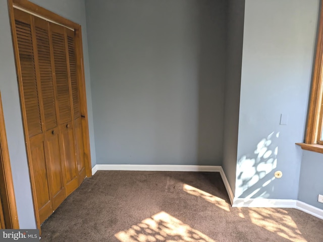 unfurnished bedroom featuring baseboards, a closet, and carpet