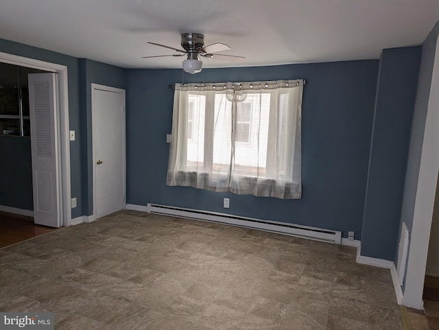 spare room with a baseboard heating unit, baseboards, and ceiling fan