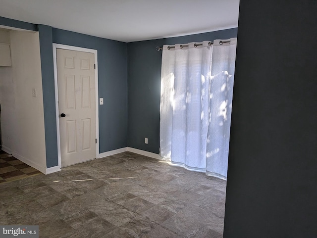 empty room featuring baseboards
