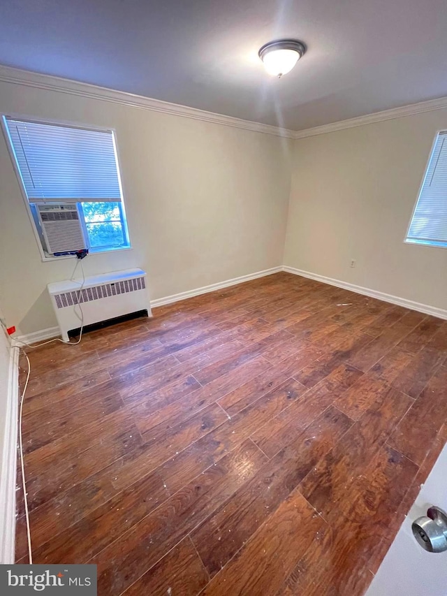 spare room featuring ornamental molding, cooling unit, radiator heating unit, and dark hardwood / wood-style flooring