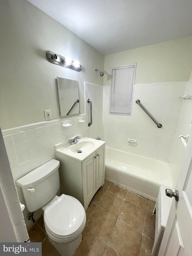 full bathroom with vanity, tiled shower / bath, tile walls, tile patterned floors, and toilet