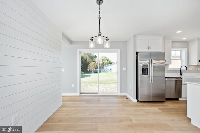 kitchen featuring plenty of natural light, appliances with stainless steel finishes, light hardwood / wood-style flooring, and white cabinetry