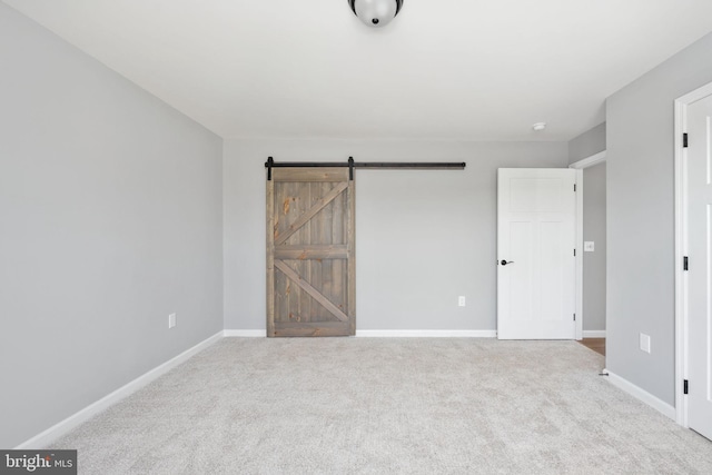 empty room with a barn door and carpet flooring