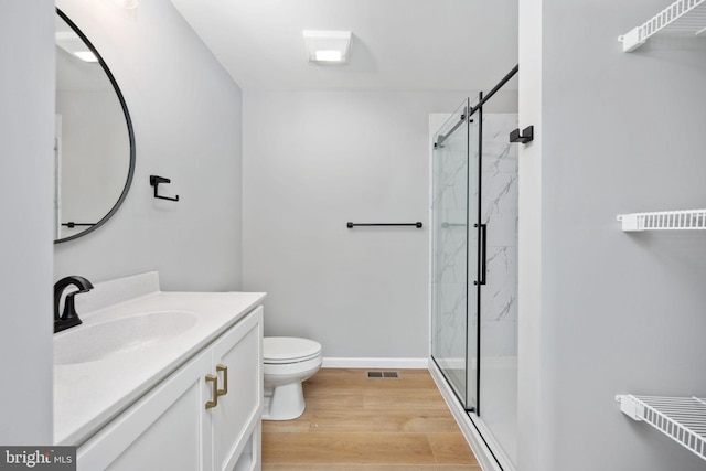 bathroom with toilet, walk in shower, vanity, and wood-type flooring