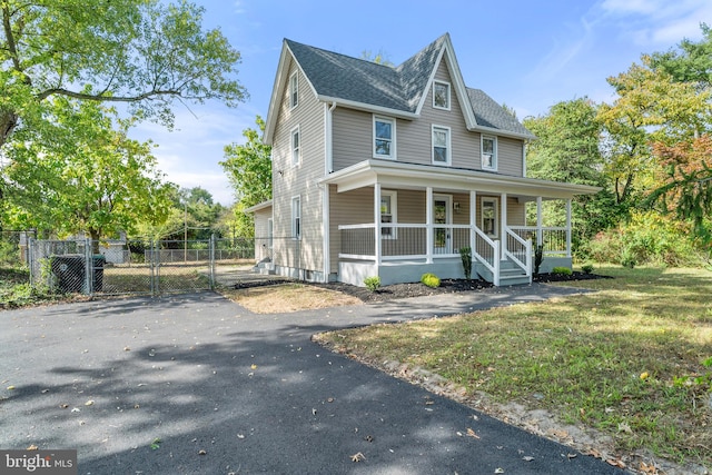 view of front facade with a front yard and covered porch