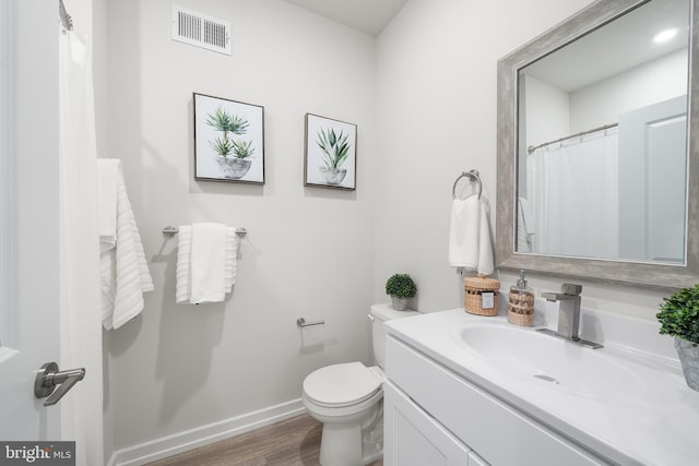 bathroom featuring hardwood / wood-style flooring, vanity, and toilet