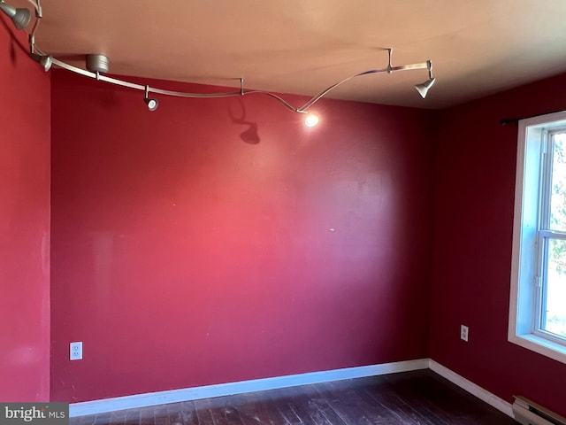 spare room featuring a wealth of natural light, a baseboard radiator, and dark hardwood / wood-style floors