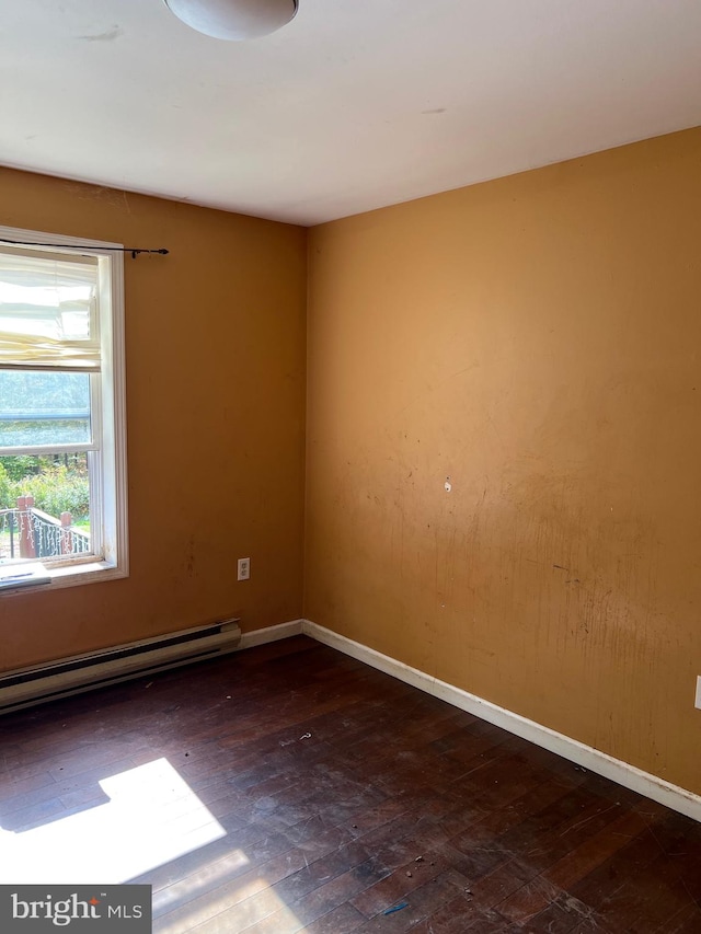 unfurnished room featuring dark hardwood / wood-style floors and baseboard heating