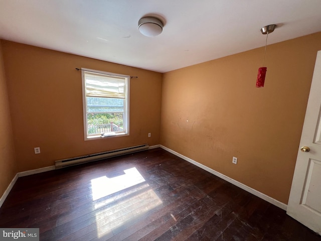 empty room with dark hardwood / wood-style floors and a baseboard heating unit