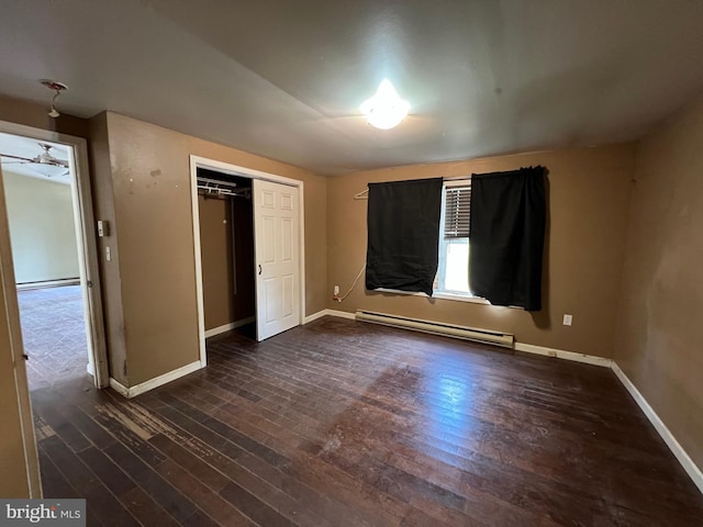 unfurnished bedroom with dark hardwood / wood-style floors and baseboard heating