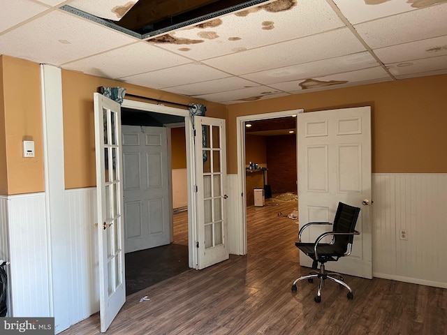 unfurnished office featuring a drop ceiling and dark wood-type flooring