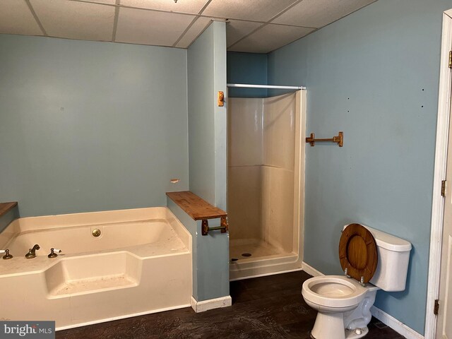 bathroom featuring a drop ceiling, plus walk in shower, wood-type flooring, and toilet