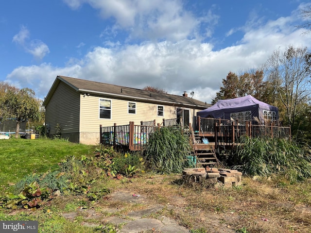 back of property with a trampoline and a wooden deck