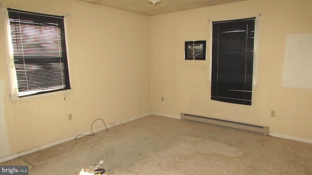 spare room featuring baseboard heating and light colored carpet