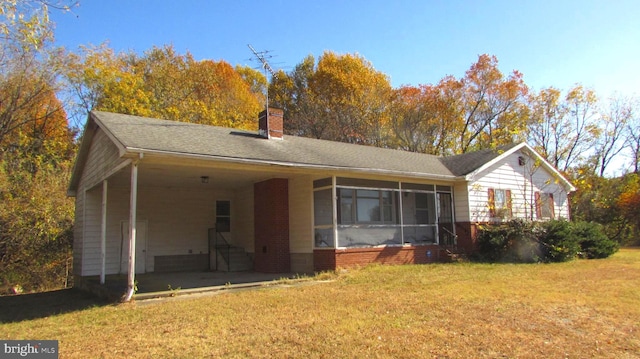 back of property featuring a yard and a sunroom