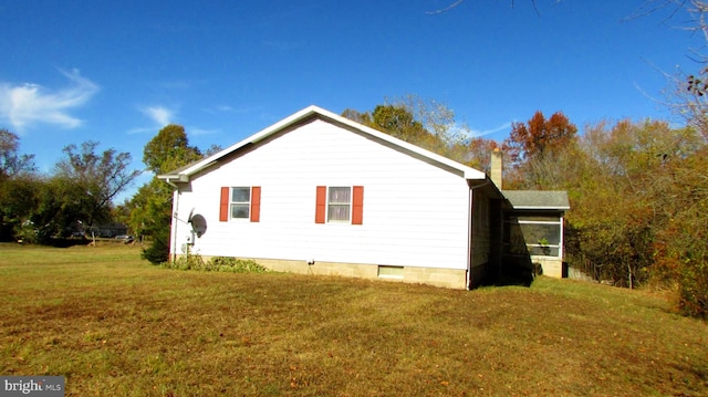 view of side of home featuring a sunroom and a lawn