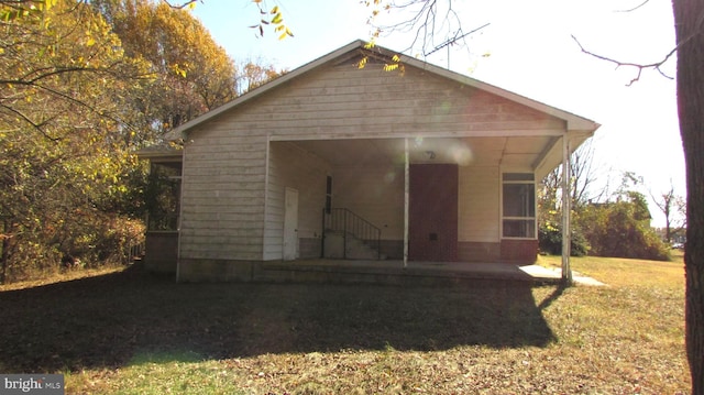 rear view of property featuring a lawn