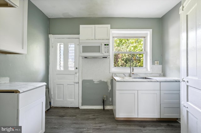 clothes washing area with dark wood-type flooring and sink