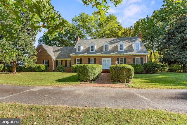 cape cod-style house featuring a front lawn