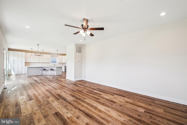 unfurnished living room with visible vents, baseboards, a ceiling fan, recessed lighting, and wood finished floors
