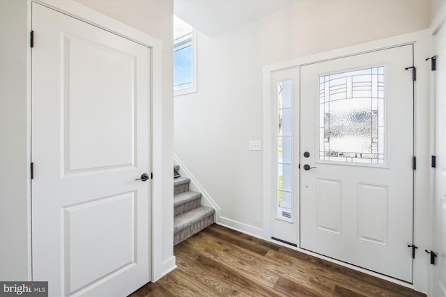 entrance foyer featuring stairway, dark wood-style flooring, baseboards, and visible vents