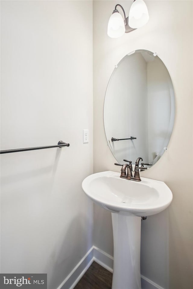 bathroom with baseboards, a sink, and wood finished floors