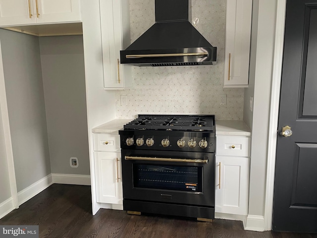 kitchen with dark hardwood / wood-style floors, tasteful backsplash, stainless steel stove, wall chimney exhaust hood, and white cabinetry