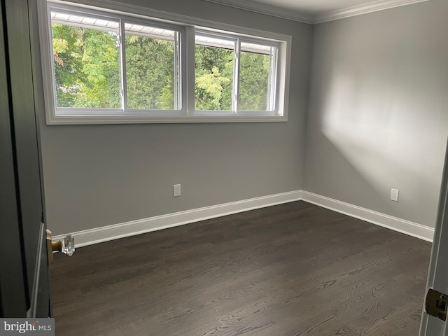 unfurnished room featuring ornamental molding and dark hardwood / wood-style flooring