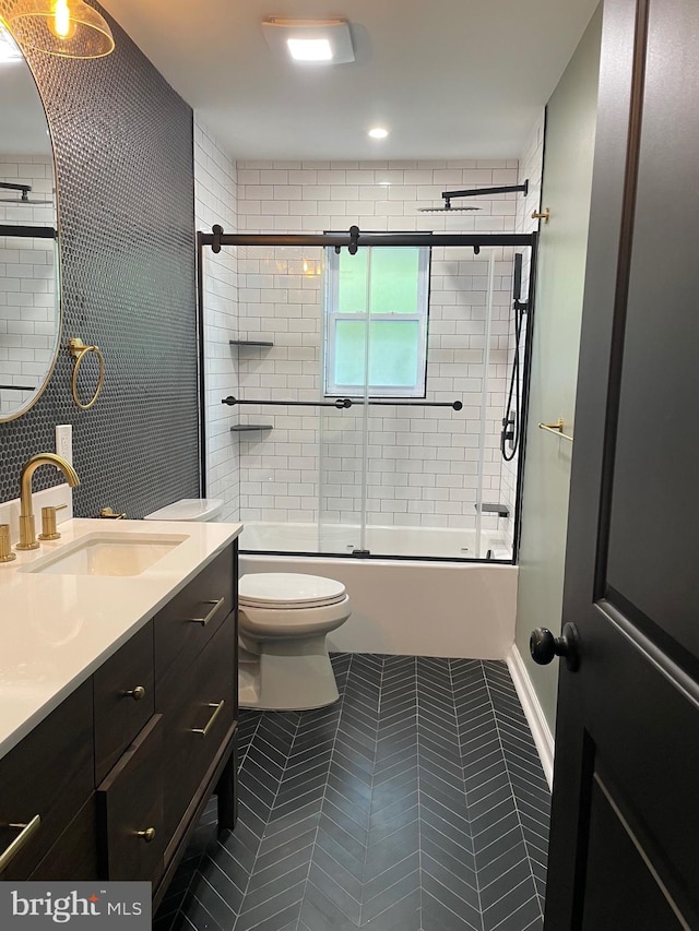 full bathroom with tile patterned floors, shower / bath combination with glass door, vanity, and toilet