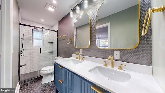 bathroom with decorative backsplash, vanity, tile walls, a shower with shower door, and toilet