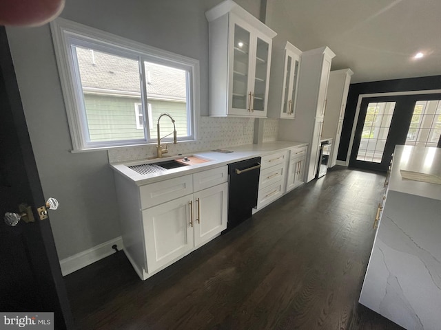 kitchen featuring dark wood-type flooring, sink, dishwasher, white cabinetry, and backsplash