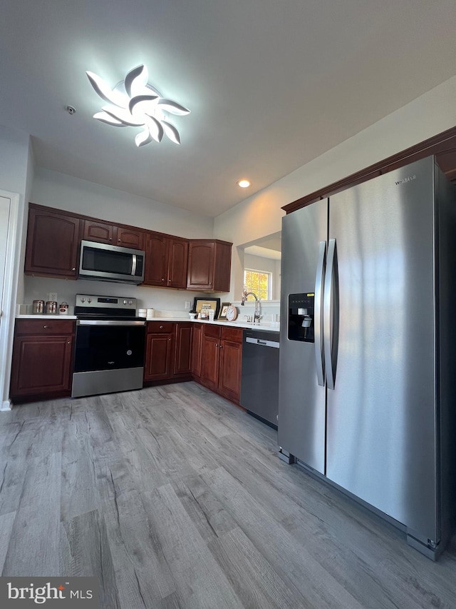 kitchen with light wood-type flooring and appliances with stainless steel finishes