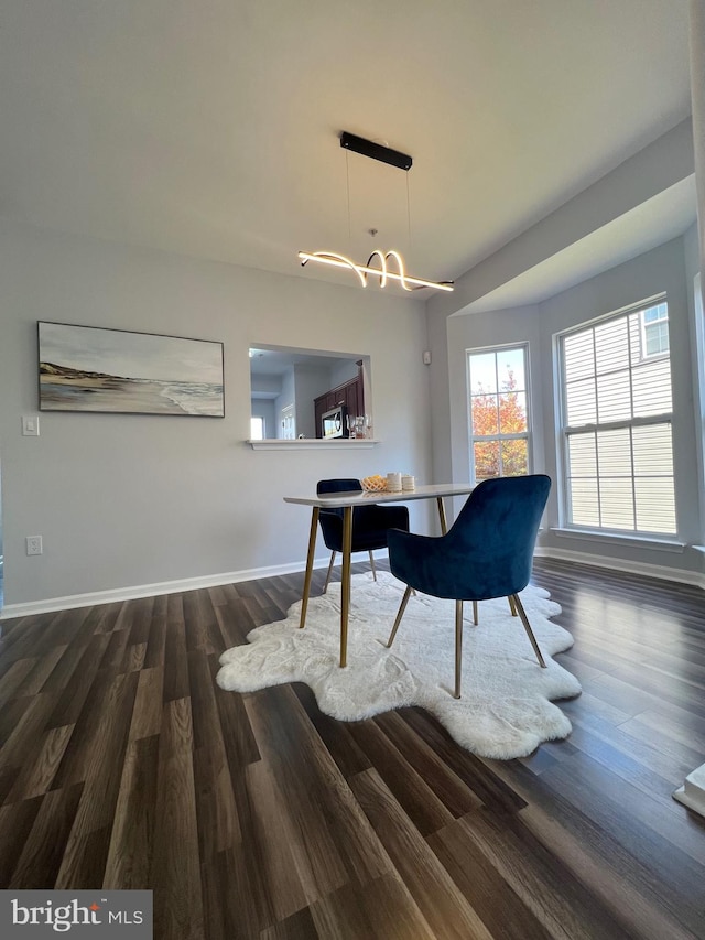 dining space with dark hardwood / wood-style floors and a chandelier