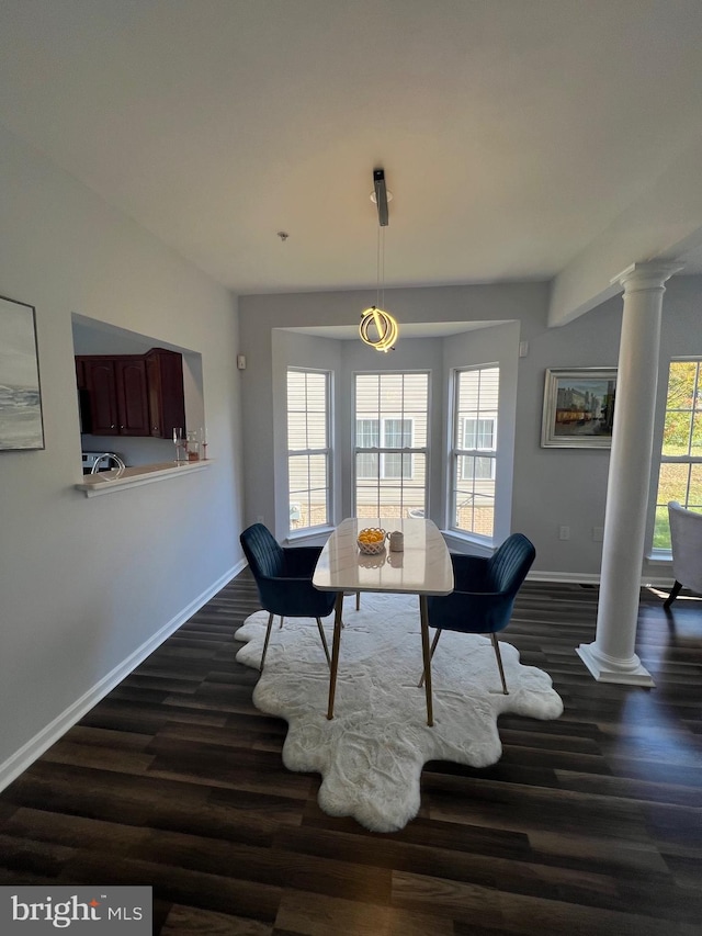 dining space with decorative columns and dark hardwood / wood-style floors