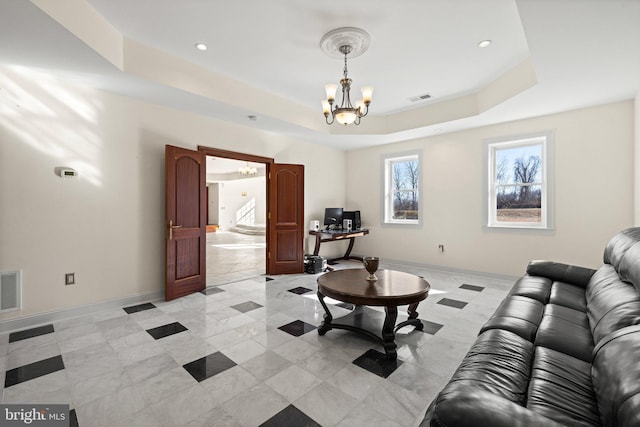 living room with an inviting chandelier, baseboards, visible vents, and a tray ceiling