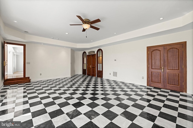 spare room featuring arched walkways, a raised ceiling, visible vents, and recessed lighting