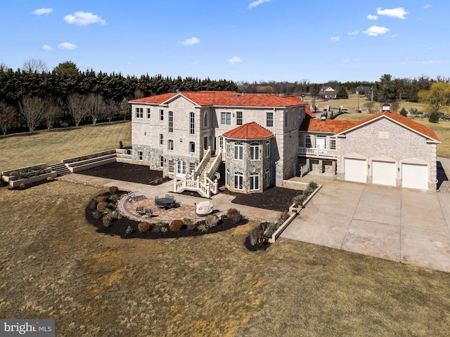 view of front of property featuring stairs, concrete driveway, a patio, and stone siding